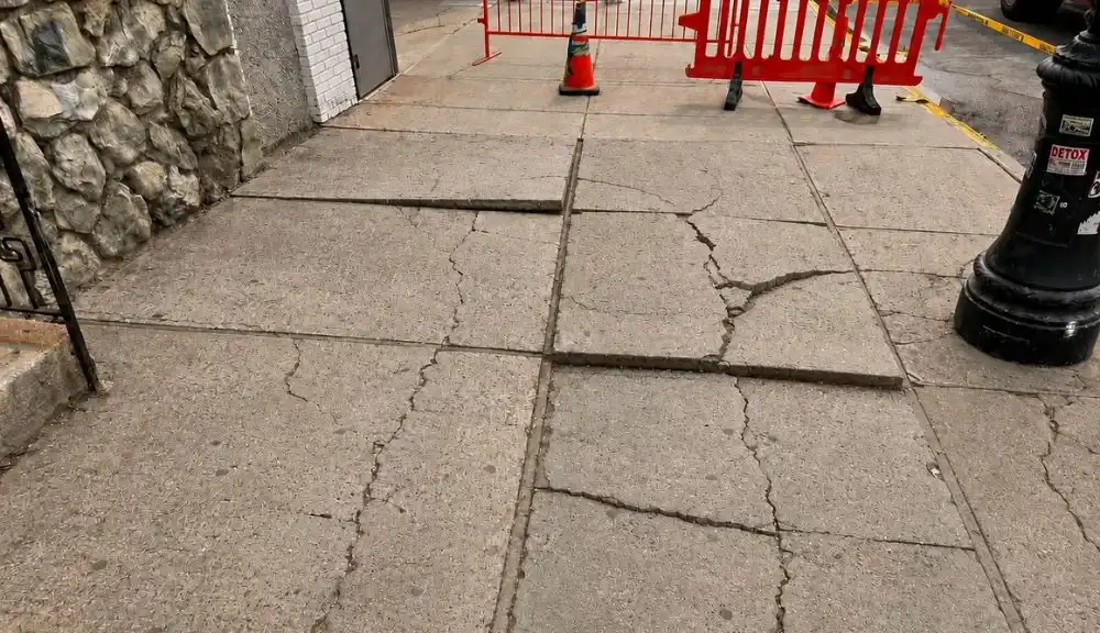 cracked raised and uneven sidewalk flags before violation repair in maspeth queens