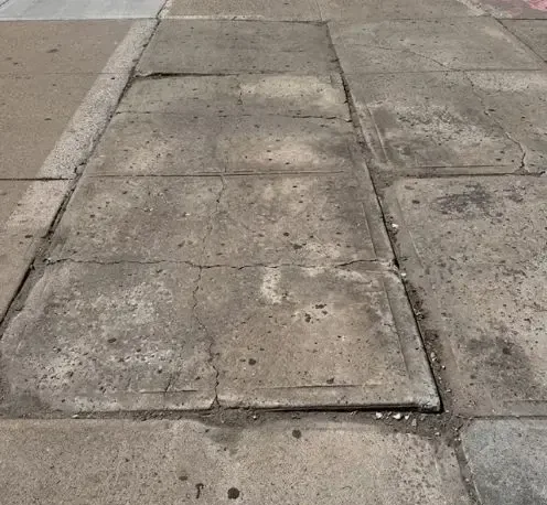 cracked and settled sidewalk slabs before dot violation repair at 646 malcolm x blvd in harlem manhattan