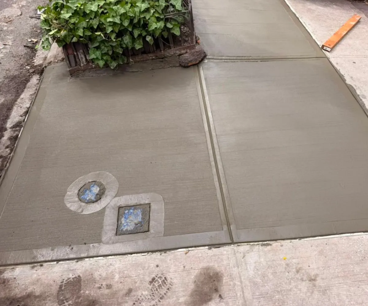 Newly replaced concrete sidewalk slabs after tree root damage repair at a residential property in Murray Hill, NYC.
